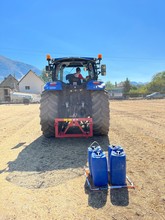 Prendre les bidons avec le crochet sur le relevage arrière, et les poser dans le carré tracé au sol.